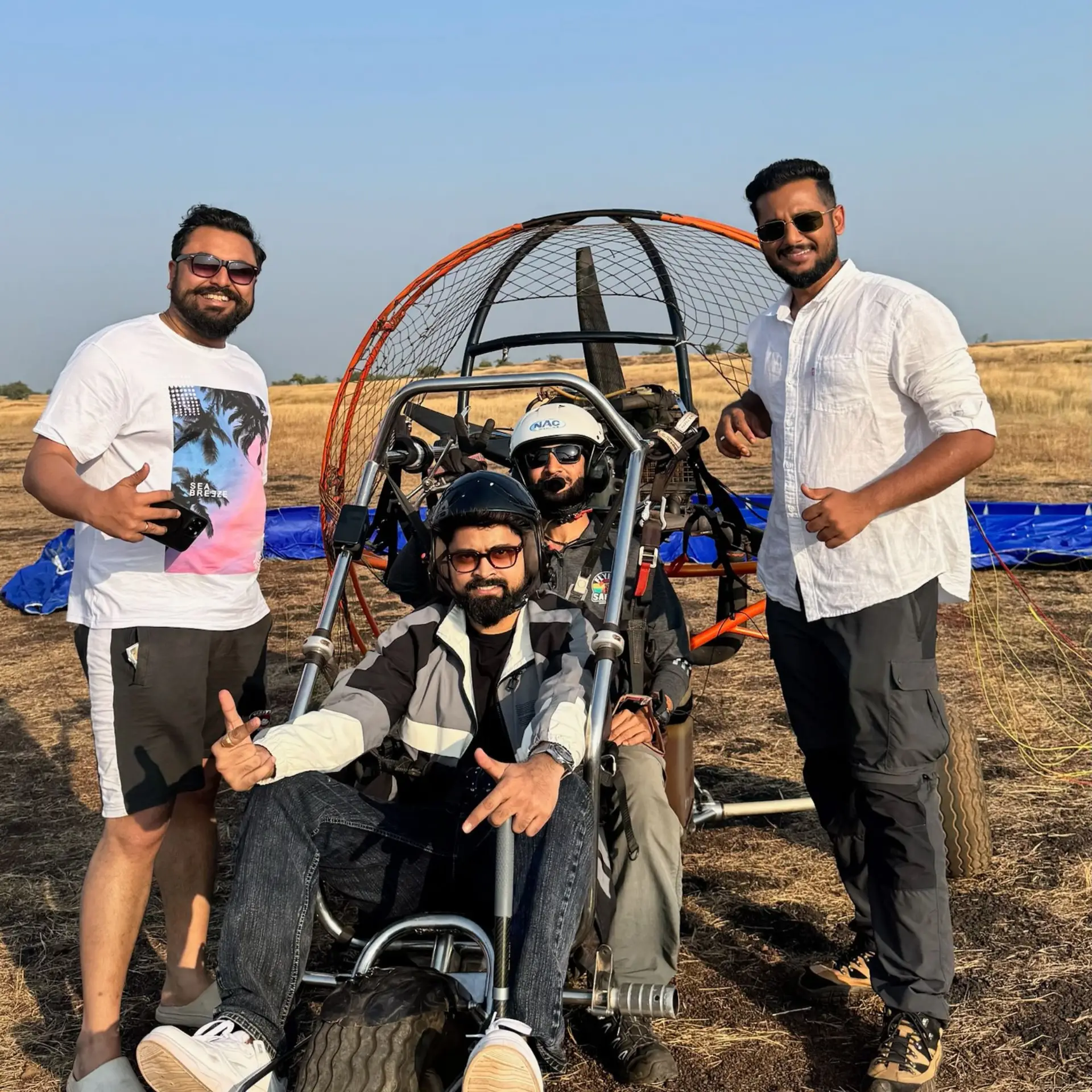 Kushal Mistry waving to the camera while flying above Goa’s lush landscapes
